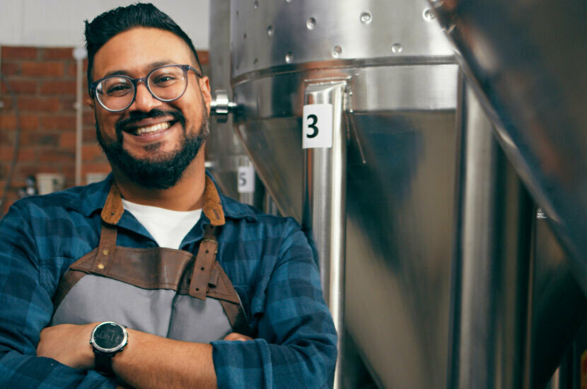 Image of a brewer smiling, representing printing labels on demand from your own facility.